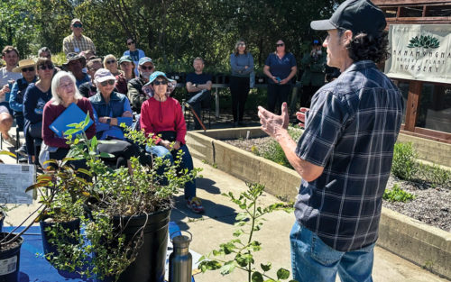 A Man Gives a Presentation to People at the Hahamonga Native Plant Nursery