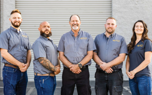 The Foundation Repair LA team stands together in front of a wall.
